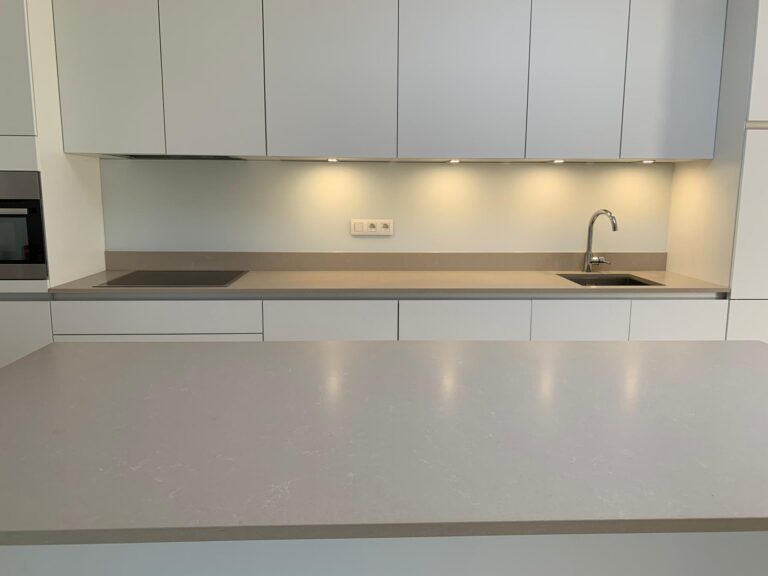 grijs gelakte glazen spatwand in moderne keuken