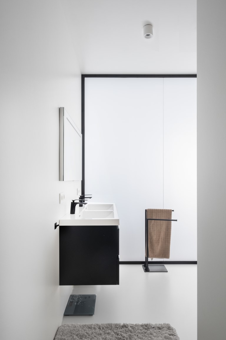 glazen wand in verzuurd glas om daglicht binnen te laten in een badkamer zonder ramen