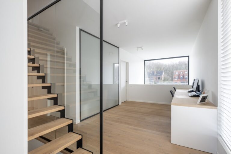 Een glazen wand als balustrade naast de trap en een glazen wand in verzuurd glas voor de badkamer.