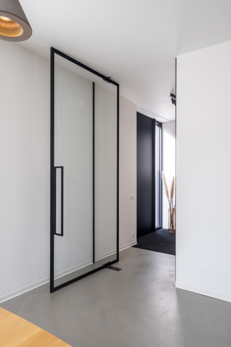 glazen deur in steellook met fijne profielen op de muren voor perfecte aansluiting